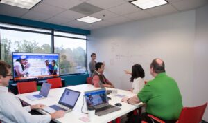 RTS Labs employees in a meeting room, window on left, white board on right side