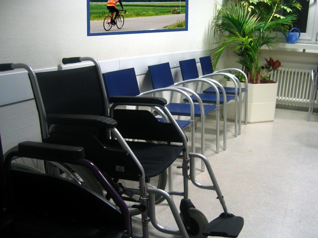 wheelchair and row of blue and silver chairs in doctor waiting room