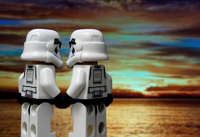 two lego stormtroopers holding hands and watching sunset