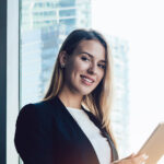 Smiling businesswoman using tablet in modern office building