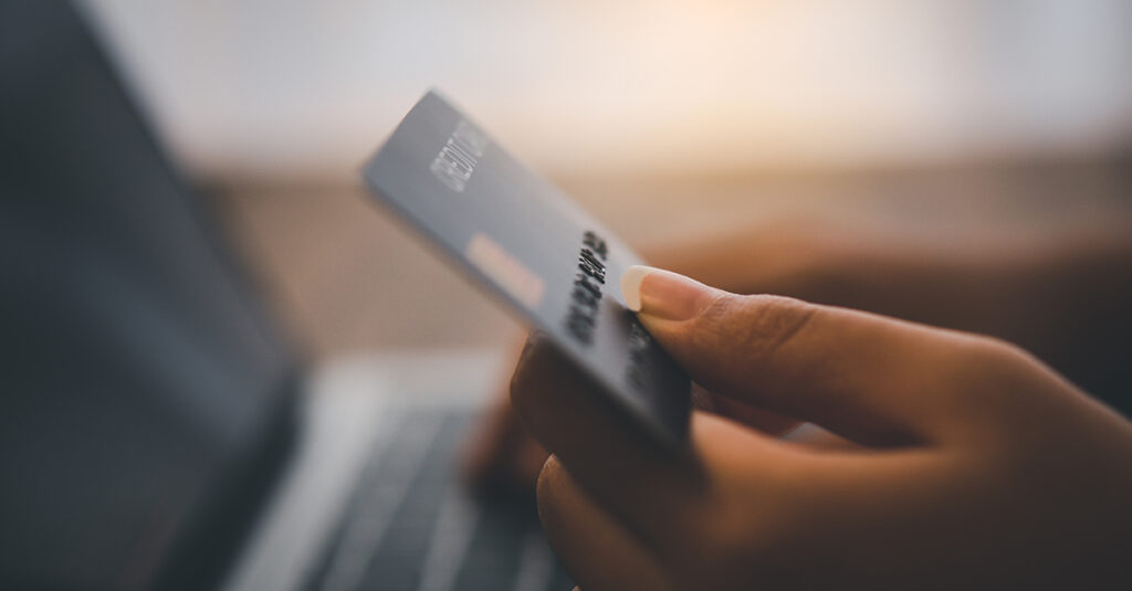 Women's hands holding a credit card and work on laptop Online pa