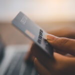 Women's hands holding a credit card and work on laptop Online pa