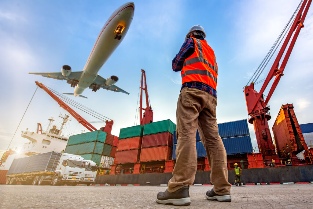 Planes, trucks, and boats in front of a man wearing a safety vest showing the increased efficiency of AI in logistics and transportation