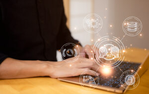 Man working on computer with AI graphics radiating out of screen.