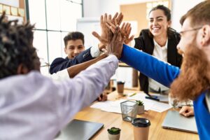 Group of tech workers smiling happy celebrating with hands together after a successful generative AI consulting project.