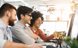 An ai consulting firm team looking at a computer hard at work.