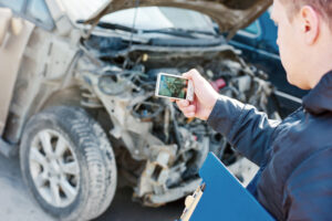 Man taking picture of car wreck.