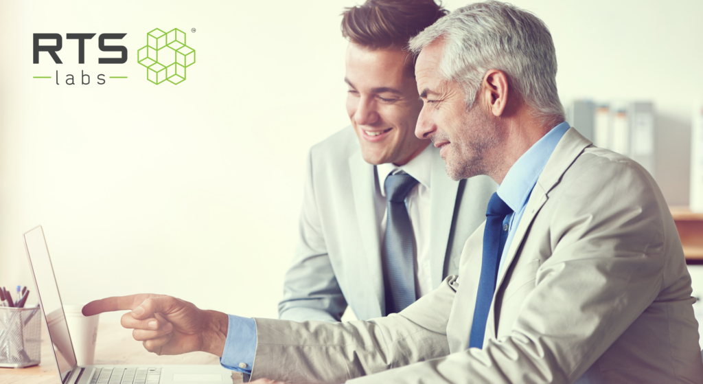 Two businessmen looking excited at a computer because they are going to build scalable AI