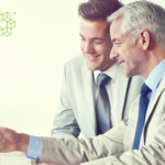 Two businessmen looking excitedly at a computer as they build scalable ai for their business.