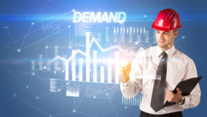 A business man in a hard hat seeing upward sales due to demand forecasting with AI