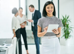 A woman on a tablet smiling because she's working with ai in marketing