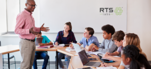 A black teacher man talking to his students with computers using ai in education.