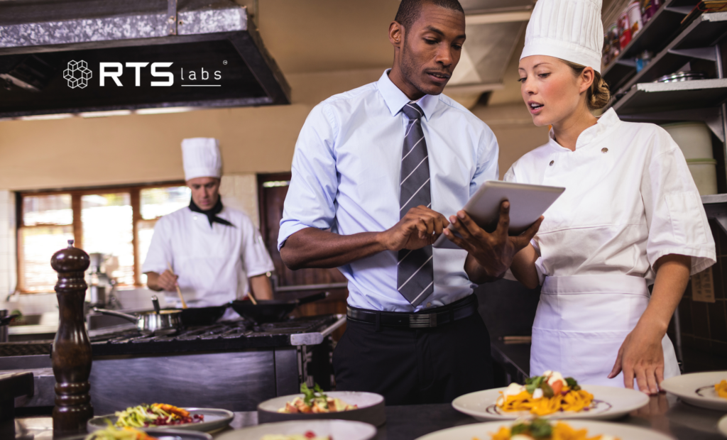 restaurant manager and female chef looking at a tablet using ai in the hospitality industry