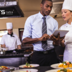 restaurant manager and female chef looking at a tablet using ai in the hospitality industry