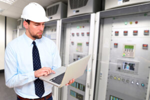 Man in hard hat working in a server room.