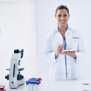 Scientist smiling and taking notes.