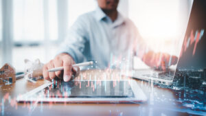 Man crunching the numbers on tablet and computer