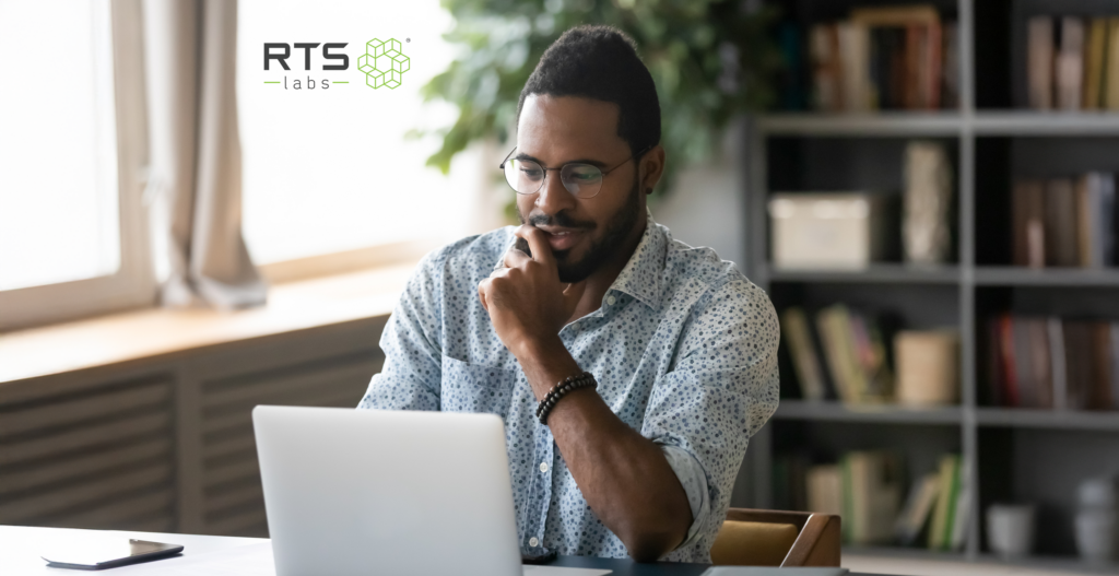 An African-American man smiling at his computer thinking about a future with AI as a moral partner