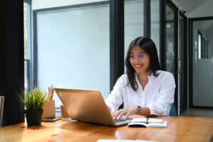 Woman looking at computer excited to use AI as a moral partner in her life.