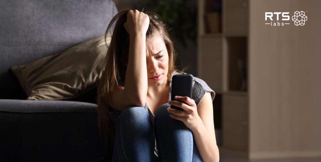 a teenage girl looking at her phone anxiously. She could use some AI in mental health benefits.