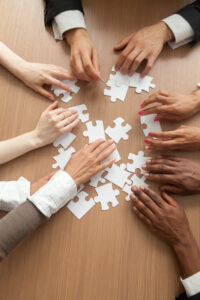 hands putting together a puzzle like devising an effective AI strategy.