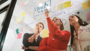 Team writing on a clear board steps to an effective AI strategy.