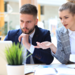 Two coworkers reading an AI consulting services guide