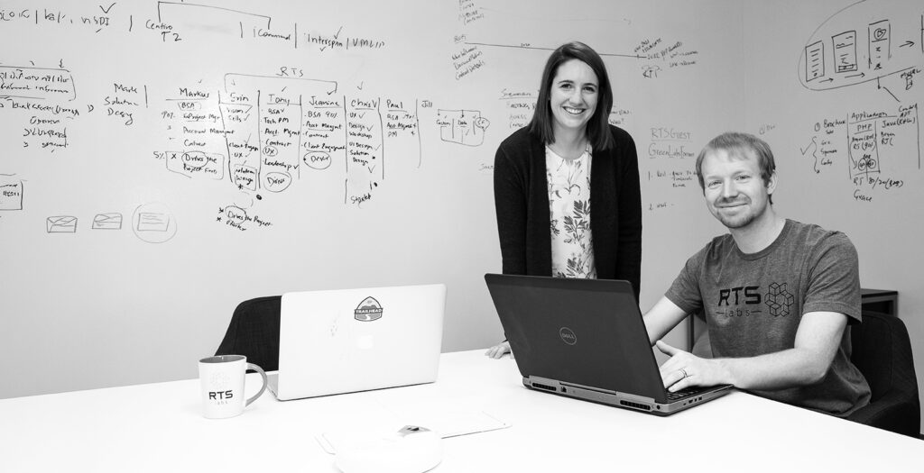 Two RTS Labs team members at a whiteboard