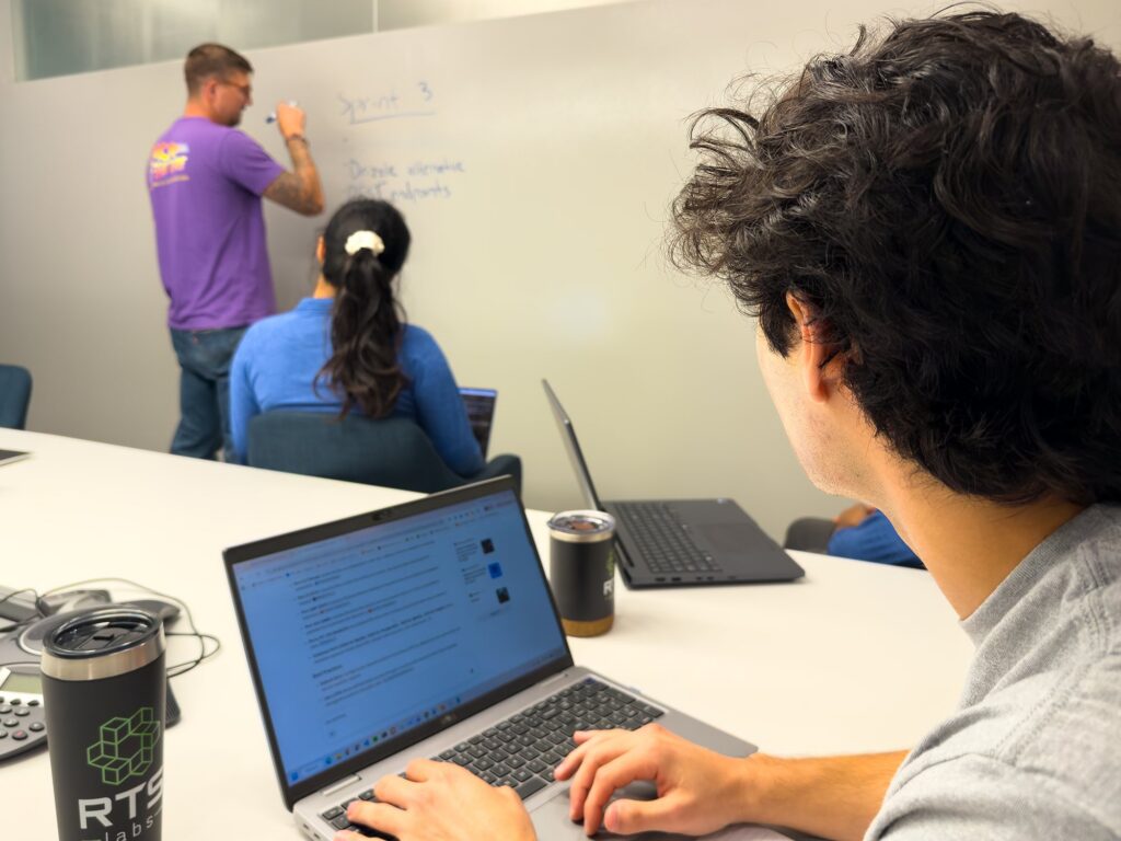 RTS Labs team working through a plan at the whiteboard